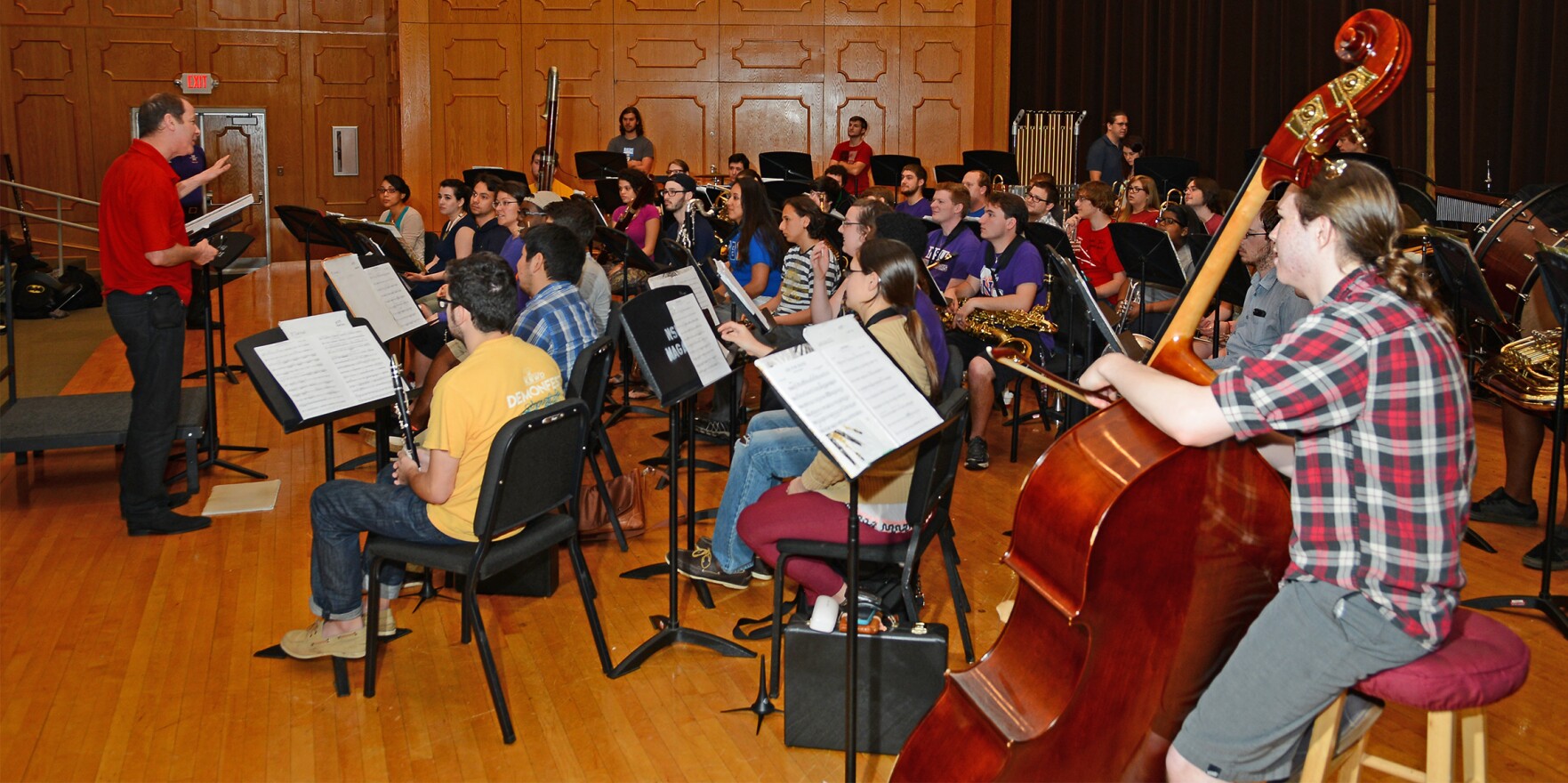 Composer Nigel Clarke (left) speaks to members of the Northwestern State Wind Symphony during a rehearsal.